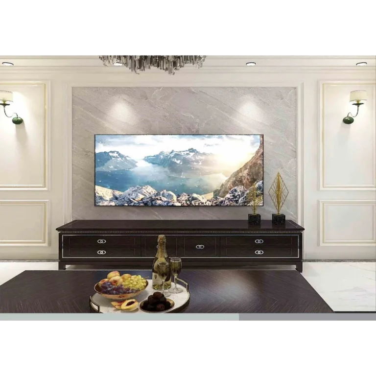 Desert Stone Matt E162 nappali. Ez a nappali egy elegáns, márványmintás PVC falpanellel és modern sötét TV-állvánnyal van felszerelve.